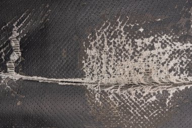 Deri ofis koltuğu arkaplan dokusunda yırtık siyah kumaş. eskimiş döşeme sandalyesi