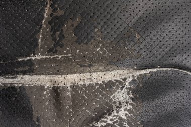 Deri ofis koltuğu arkaplan dokusunda yırtık siyah kumaş. eskimiş döşeme sandalyesi