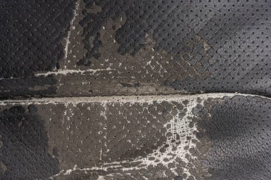Deri ofis koltuğu arkaplan dokusunda yırtık siyah kumaş. eskimiş döşeme sandalyesi