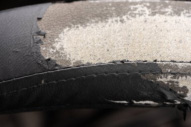 Deri ofis koltuğu arkaplan dokusunda yırtık siyah kumaş. eskimiş döşeme sandalyesi