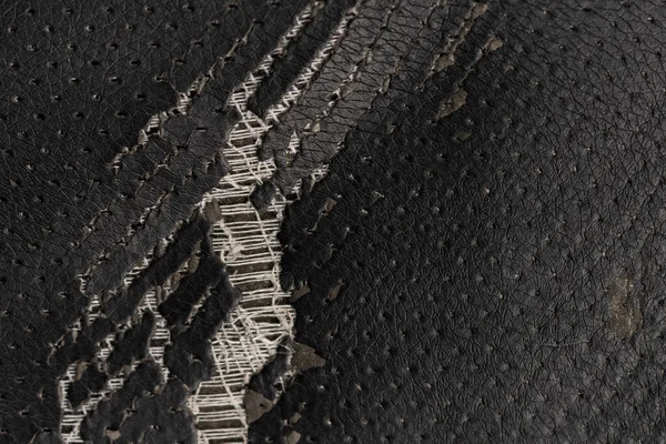 Deri ofis koltuğu arkaplan dokusunda yırtık siyah kumaş. eskimiş döşeme sandalyesi