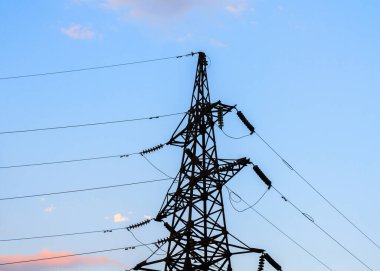 Açık havada elektrik iletim pilonunun silueti..