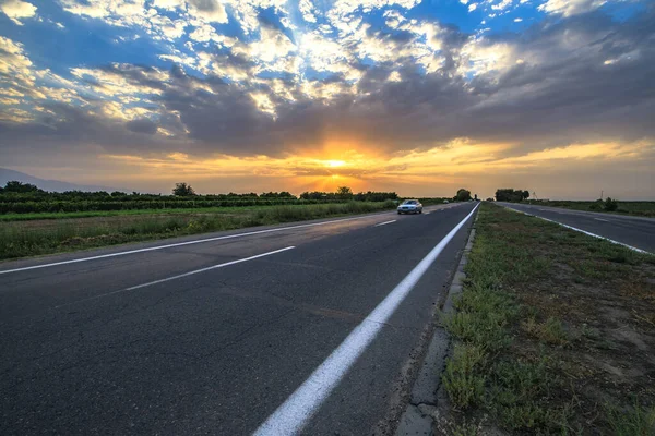 Paisagem Dramática Pôr Sol Com Uma Estrada Rural Carro — Fotografia de Stock