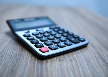 Hesap makinesini ahşap masa ve muhasebe konseptine kapat. 