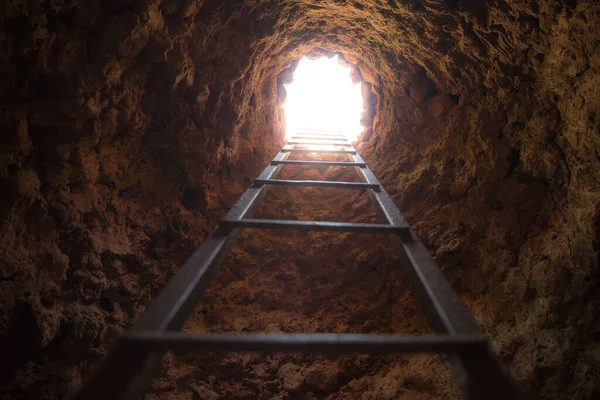 Stairs leading to the end of the cave light, symbol of hope.