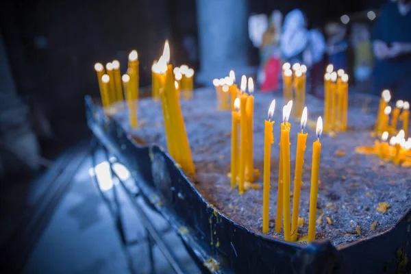 在教堂里 用沙子在手册上点燃的稀疏的蜡烛 — 图库照片