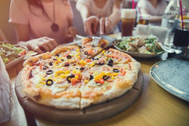 İnsanların ellerinin pizza dilimlerini almasına yakın dur.. 