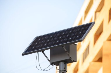 Bulutlu mavi bir gökyüzü üzerinde çalışan güneş paneli ile kamu kentsel ışığı.