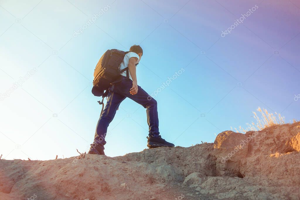 Hiker with backpack on top of mountain looking at beautiful landscape.