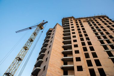 Bir bina ve inşaat vincinin altından görüntüle. 