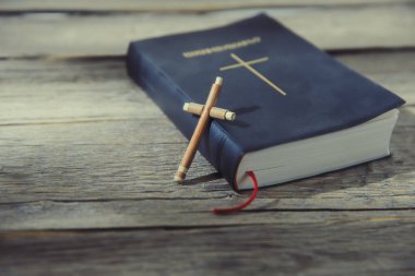 Kutsal İncil ve ahşap haç küçük ahşap masada..