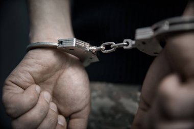 Yetişkin erkek tutuklandı ve kelepçelendi