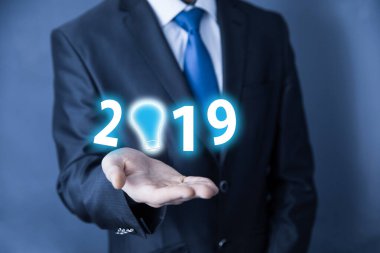 İş adamı elinde ampulle 2019 yılına ait fikir geliştirme teknolojisini tutuyor.