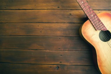 Gitar ahşap masanın arkasında.