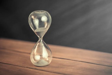 Ahşap masa arkasında kum saati.