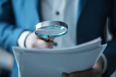 İş adamı el büyüteçle belgelendirmesi