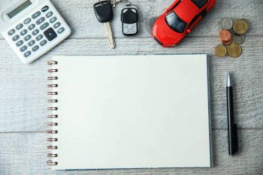 Masasında not defteri ve arabası olan hesap makinesi