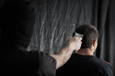 Silahlı maskeli soyguncu anneye nişan alıyor.