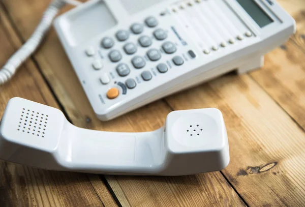 木製のテーブルの上の白い電話 — ストック写真