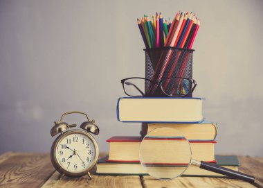 Renkli kalemler ve masa üzerinde saat.