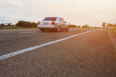 Araba gün batımında yolda.