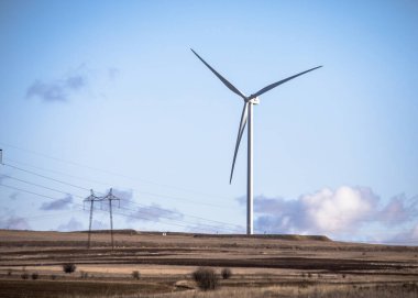 Çayırlarda elektrik üreten bir yel değirmeni