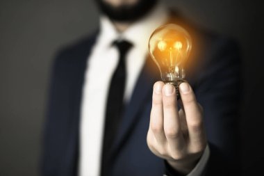 Adam el ele tutuşup ampulü tutuyor.