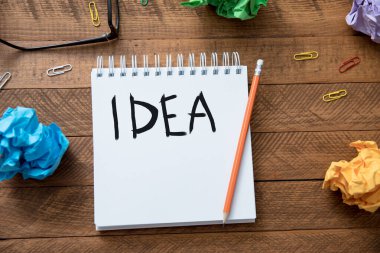 Fikir metni masadaki kağıtlarla birlikte deftere yazılır