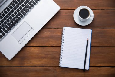 Not defteri ve bir fincan kahveyi masaya koy.