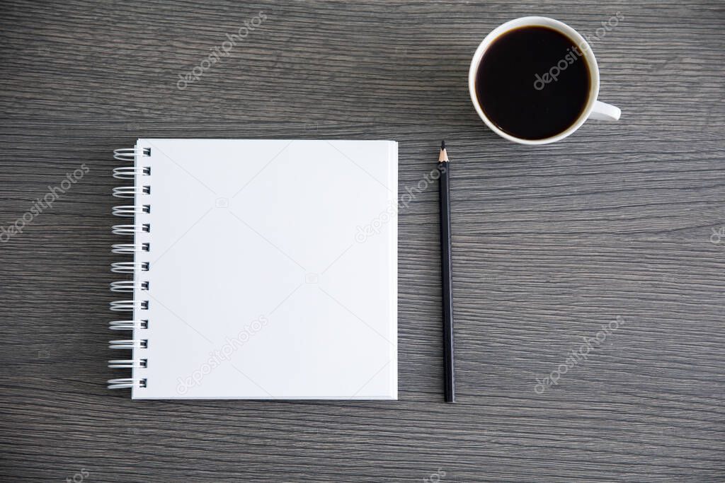 notepad with cup of coffee on des