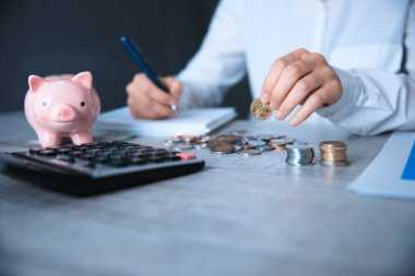 Bir adam hesap makinesi ve not defteri ile para uzatır.