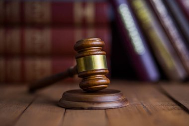 Tahta masa üzerinde kitapları olan bir yargıç.