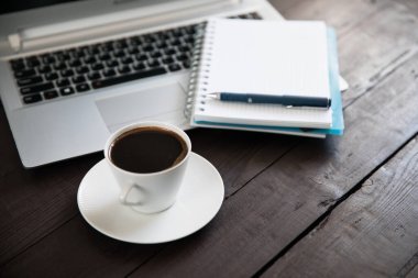 Klavyede not defteri ve üzerinde kahve var.