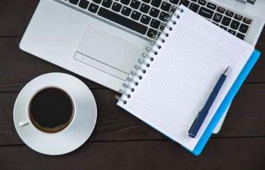 Bir fincan kahve ve bilgisayar klavyeli not defteri