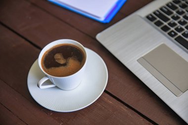 Üzerinde bilgisayar klavyesi olan bir fincan kahve.