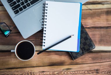 Klavyede not defteri ve üzerinde kahve var.