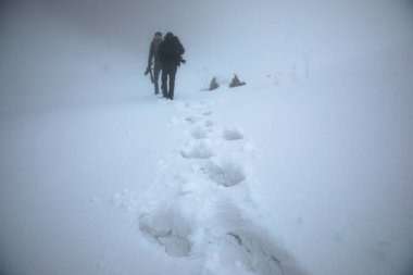 Adam kışın sisli dağ yolunda
