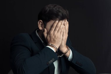 Üzgün adam elleri kelepçeli.