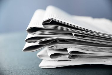 Gri arka planda gazete yığını