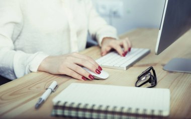 Ofisteki bilgisayarda çalışan kadın.