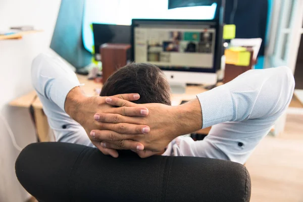 man holding hand on the back of the head and working  at the des