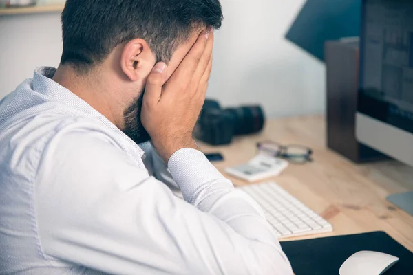 sad worker hand in face in the office des