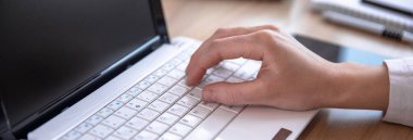 İş yerinde dizüstü bilgisayarda yazan kadın.