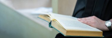 Bayan öğrenci içeride kitap okuyor.