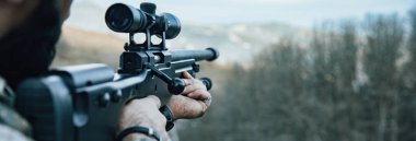 Askerin elinde keskin nişancı tüfeği var.