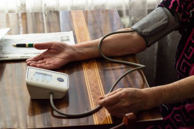 Yaşlı bir adam yandan basınç ölçümü