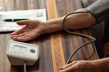 Yaşlı bir adam yandan basınç ölçümü