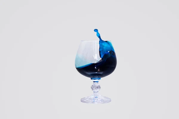 Glas Mit Farbiger Flüssigkeit Und Spritzwasser Auf Weißem Hintergrund — Stockfoto
