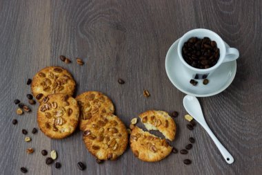 Bir fincan kahvenin yanındaki masada kurabiye fıstık ile yalan