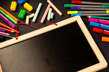 Siyah bir arka plan üzerine çizmek için kalem farklı renkleri, boya kalemi ve bir ahşap tahta hissettim